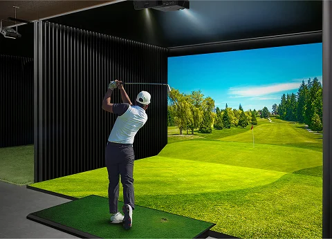 Golfer swinging in a Shotgun Golf TrackMan simulator bay
