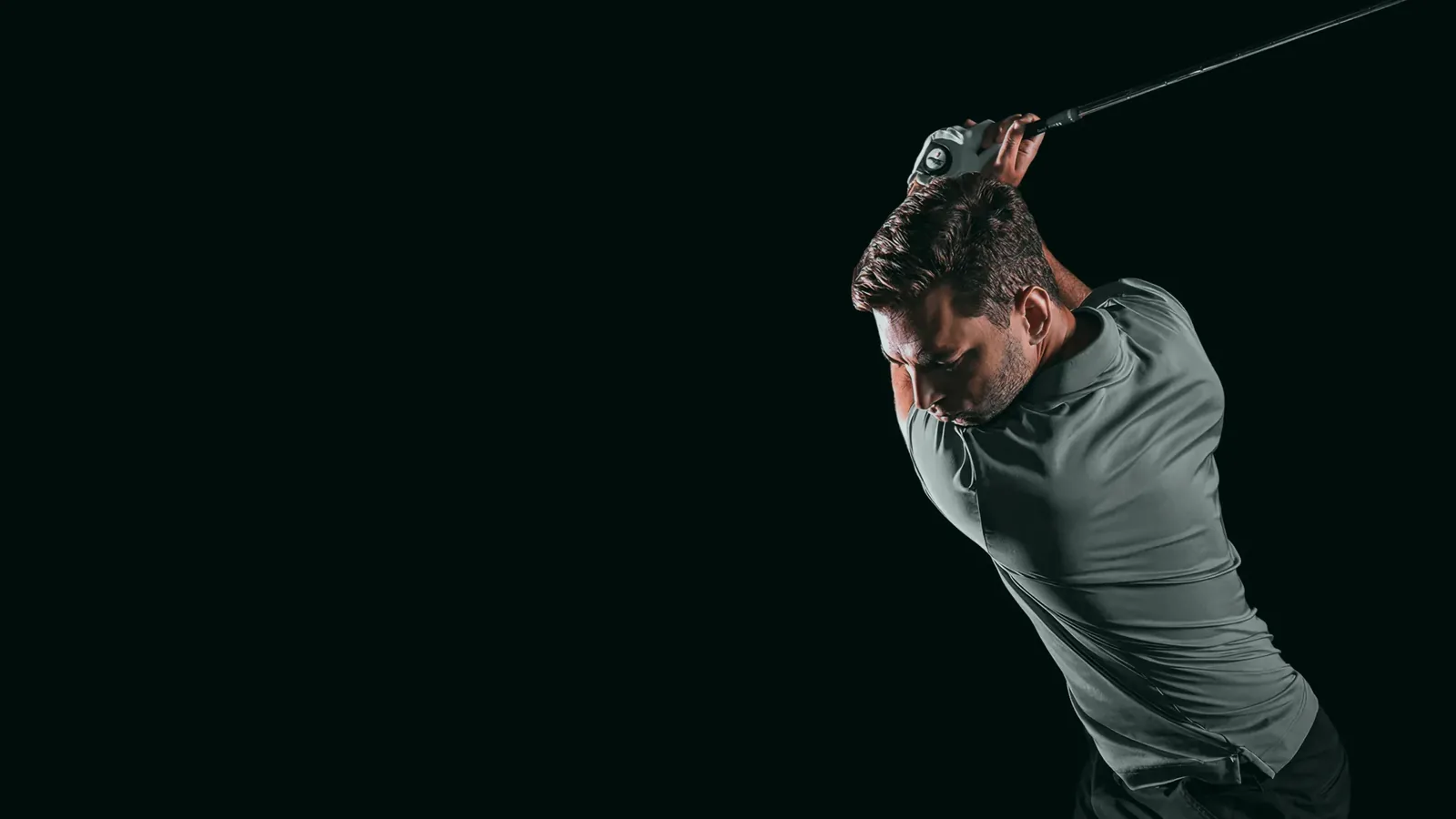 A golfer mid-swing in a Shotgun Golf bay