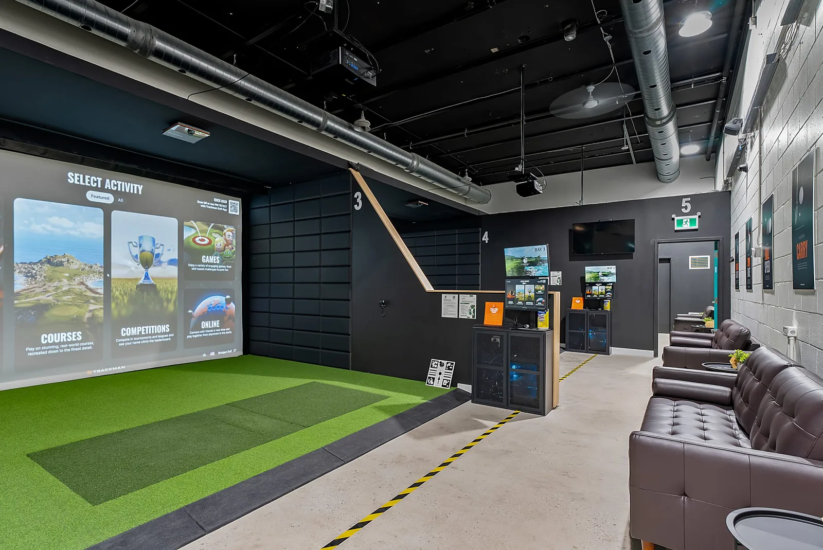 An empty Shotgun Golf bay with the TrackMan activity screen showing courses, competitions and online play